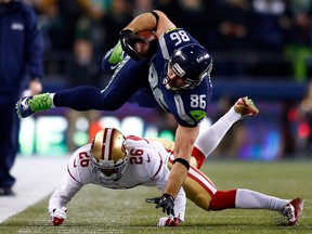 Seahawks' Zach Miller is tackled by 49ers' Tramaine Brock during the NFC Championship at CenturyLink Field in Seattle on Sunday. (GETTY IMAGES)