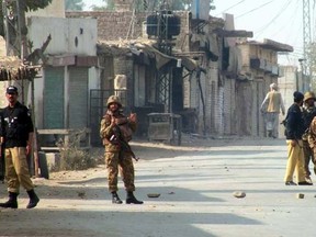 Pakistani soldiers cordon off a street leading to the site of a bomb attack on a security convoy in the city of Bannu on January 19, 2014. AFP PHOTO/KARIM ULLAH