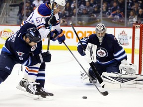 Jan 18, 2014; Winnipeg, Manitoba, CAN; Winnipeg Jets defenseman Mark Stuart (5) defends against Edmonton Oilers forward David Perron (57) as Winnipeg Jets goalie Ondrej Pavelec (31) gets ready for a shot during the first period against the Edmonton Oilers at MTS Centre. Mandatory Credit: Bruce Fedyck-USA TODAY Sports