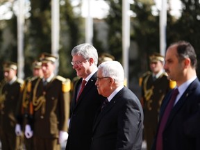 Palestinian President Mahmoud Abbas walks with Canadian Prime Minister Stephen Harper as they review an honour guard ceremony in the West Bank town of Ramallah January 20, 2014. Harper is on a four-day visit to Israel and the Palestinian Territories. REUTERS/Mohamad Torokman
