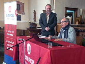 Rev. Jim Evans, left, of New Vision Community Church in St. Thomas, looks on as former CAW president and advocate for clergy rights Buzz Hargrove congratulates the members and executive of the new Unifor Unifaith Community Chapter.