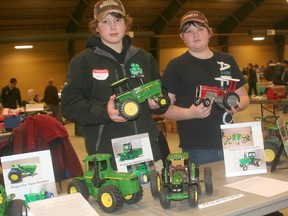 Dylan Lamers, 14, of Blenheim, left, and Colin Scott, 14, of Ridgetown, pose with their model John Deere and Massey Ferguson tractors they restored as members of the 4-H Toy Club. The club's annual toy and show sale took place at the John D. Bradley Centre on Jan. 19.