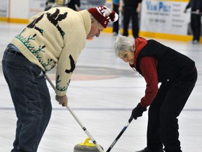 Dave Smith (left) and Elsie Beuermann sweep the stone into the house during first draw action from the Mitchell Curling Club bonspiel Jan. 18. ANDY BADER/MITCHELL ADVOCATE