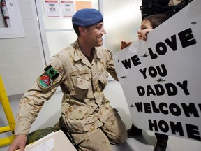 Cpl. Cameron Lane, traffic technician with 2 Air Movements Squadron at 8 Wing/CFB Trenton, Ont., reunites with his three-year-old son Aidan as he returns home after serving a six-month tour in Afghanistan during Operation Attention, at CFB Trenton Monday, Jan. 20, 2014. - JEROME LESSARD/The Intelligencer/QMI Agency