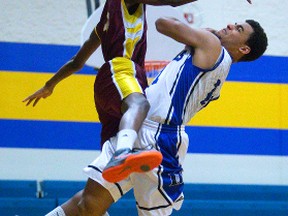 Donovan Selmes-Thom of the Raiders is fouled by Banting?s Bruno Pande while driving to the hoop during their TVRA Central senior boys? basketball game at Beal on Monday.  (MIKE HENSEN, The London Free Press)