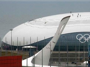 Workers stand atop the roof of the Bolshoy Ice Dome in the Adler district of Sochi January 20, 2014. Sochi will host the 2014 Winter Olympic Games from February 7 to February 23. REUTERS/Alexander Demianchuk