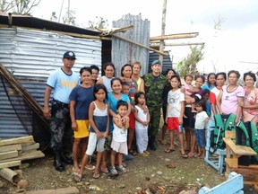 Capt. Christopher Daniel poses for group photo with the local residents of an island community in Pontevedra, Capiz. “The locals were smiling, resilient and hopeful albeit the calamity that hit their community,” he said. - Photo by: Philippine National Police