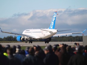 Bombardier employees and guests watch the CSeries aircraft taxi on the runway for its first test flight in Mirabel, Que., in this September 16, 2013 file photo. (REUTERS/Christinne Muschi)