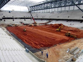 Workmen stand next to the pitch inside the Arena da Baixada stadium as work continues in preparation for the 2014 FIFA World Cup soccer championship in Curitiba December 11, 2013. (REUTERS)