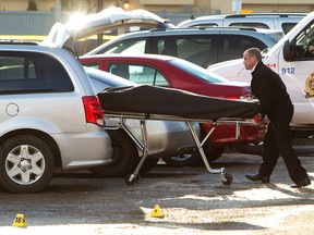 A body is removed from the scene of a fatal early morning shooting outside the Hudson's Canadian Tap House, 11248 - 104 Ave., in Edmonton, Alta., on Tuesday Jan. 21,  2014. David Bloom/Edmonton Sun
