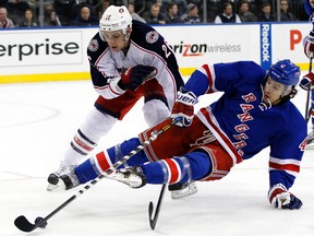 New York Rangers defenceman Michael Del Zotto is tripped up by Columbus Blue Jackets forward Corey Tropp during NHL action at Madison Square Garden. (Adam Hunger/USA TODAY Sports)