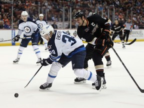 Tobias Enstrom of the Winnipeg Jets is pursued by Ryan Getzlaf of the Anaheim Ducks for the puck in the first period at Honda Center on January 21, 2014. (Jeff Gross/Getty Images/AFP)