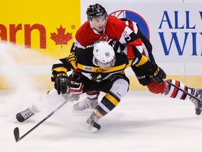 Ottawa 67’s Adrian Sloboda checks the Kingston Frontenacs’ Mack Lemmon during Ontario Hockey League action at the Canadian Tire Centre in Ottawa Wednesday night. (Errol McGihon/QMI Agency)