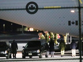 The bodies of Peter McSheffrey, 49, of Ottawa and Martin Glazer, 43, of Gatineau, Que., two senior auditors at Samson & Associates who were among foreigners killed in Afghanistan when a suicide bomber and two gunmen attacked La Taverna du Liban restaurant in Kabul last Friday, are carried out of a C-17 Globemaster at 8 Wing/CFB Trenton, Ont. as they are repatriated to Canada Wednesday, Jan. 22, 2014, just after 11 p.m. - JEROME LESSARD/THE INTELLIGENCER/QMI AGENCY