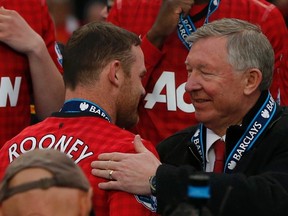 Manchester United manager Alex Ferguson speaks with Wayne Rooney during the English Premier League trophy presentation at Old Trafford stadium in Manchester, northern England May 12, 2013. (REUTERS/Phil Noble)