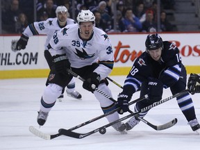 Winnipeg Jets centre Bryan Little (centre) battles for a loose puck with Logan Couture (left) and Patrick Marleau of the San Jose Sharks during NHL action at MTS Centre in Winnipeg, Man. on Sun., Nov. 10, 2013. Kevin King/Winnipeg Sun/QMI Agency