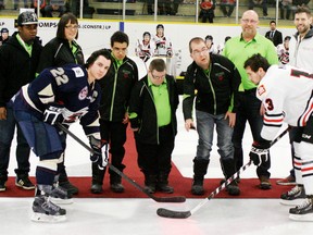 Michael Yaceyko (third from right) was joined by West Central District teammates (left to right) Evan James, Rev St. Laurent, coach Rochelle Chamczuk, Steven Van de Oetlaar, Troy Bradbury, coach Richard Yaceyko and Alberta Special Olympics president and CEO Johnny Byrne for the ceremonial face-off at a Spruce Grove Saints game. Taking the face-off  is Saints captain Corey Chorneyko and Whitecourt’s Colten Mayor. - Gord Montgomery, Reporter/Examiner