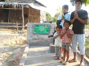 A family gives thanks for their new water well made possible by donations. - Photo Supplied