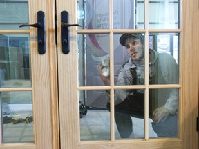 Nick Chesney polishes windows at the Douglas Window and Door display at the Lifestyle Home Show, which continues through Sunday at the Western Fair District Agriplex. (DEREK RUTTAN, The London Free Press)