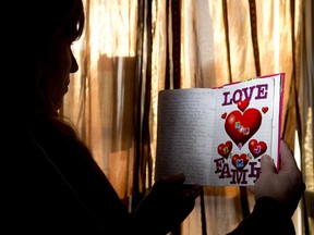 A former sex worker, Stacey, holds a journal in which she has been writing messages to her daughter, one of three children taken from her, for the past 12 years. (CRAIG GLOVER, The London Free Press)