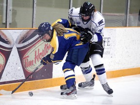 Gino Donato/The Sudbury Star
Laurentian Voyageurs Jeanne Boutin fights for the loose puck with Jennifer Sisson of UOIT during OUA womens hockey action from the Gerry McCrory Countryside Sports Complex on Sunday afternoon.