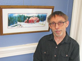 David Doyle, of Mitchell, poses by one of his watercolour paintings currently on display at the West Perth Public Library. KRISTINE JEAN/MITCHELL ADVOCATE