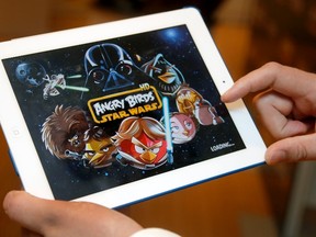 A developer plays the Angry Birds Star Wars game, at a Toys "R" Us in Times Square in New York in this handout photo released by Lucasfilm, October 8, 2012. (REUTERS/Gary He/Insider Images for Lucasfilm/Handout)