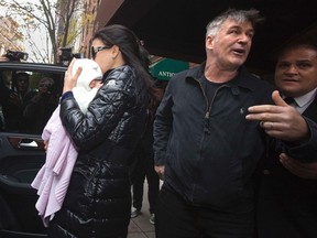 Actor Alec Baldwin demands the media step away as his wife Hilaria Thomas carries daughter Carmen into an SUV outside his apartment in New York November 15, 2013. (REUTERS/Carlo Allegri)