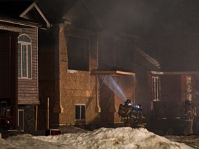 Fire crews respond to the scene of a house fire near 154 Street and 98 Avenue on Tuesday. (Codie McLachlan/Edmonton Sun)