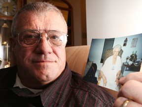 Gino Donato/The Sudbury Star  
Rino Dube of Azilda holds a photo of his mother Juliette Saindon, who was killed in the L'Isle-Verte seniors home fire last week. The official death toll has reached 17 with 15 residents still missing.