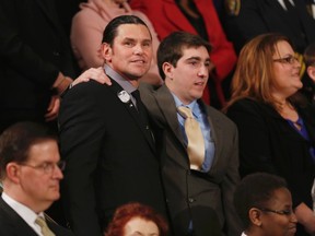 Boston Marathon bombing survivor Jeff Bauman, who had to have both his legs amputated after being injured in the blasts, stands with his rescuer Carlos Arredondo (L) before the start of U.S. President Barack Obama's State of the Union speech on Capitol Hill in Washington January 28, 2014.   REUTERS/Gary Cameron