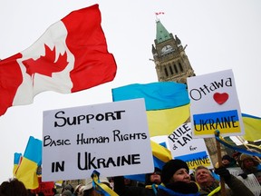 People wave Canadian and Ukranian national flags during a rally to express solidarity with anti-government protesters in Ukraine, on Parliament Hill in Ottawa January 29, 2014. The former Soviet republic has been gripped by mass street unrest since President Viktor Yanukovich walked away from a trade pact with the European Union last November, opting for closer economic ties with Russia which has brought it a $15 billion bailout package.    REUTERS/Blair Gable