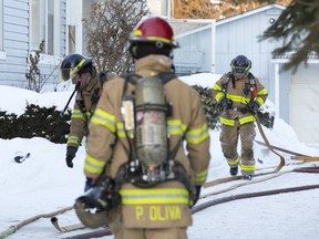 Firefighters begin to clear up equipment after battling a fire in a duplex on Campbell St. N. in London on Wednesday. One person was home when the fire started, but was able to escape the single-storey house safely.  Two dogs were killed in the fire. CRAIG GLOVER/The London Free Press/QMI Agency