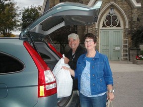 Volunteers Marilyn and Gerry load frozen meals into their car before hitting the road to deliver the meals to clients. (Courtesty of Meals on Wheels)