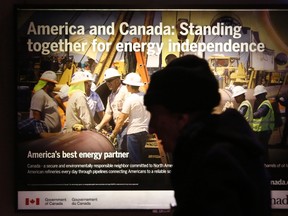 A commuter walks past advertisements promoting Canada as a preferable oil provider for America at a metro station in Washington on January 29, 2014. (REUTERS/Yuri Gripas)