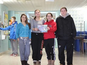 (Left to right) Oakridge secondary school Grade 9 students Emily Sosica, Jennie Riddell, Cassidy O'Brien and Jacob Pippel hold up Plan Canada's Gifts of Hope catalogue. The class donated $195 to Plan Canada to stock a pharmacy.
