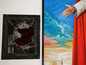 A broken glass of a niche where the reliquary with the blood of the late Pope John Paul II was located is seen next to a painting of the late Pope in the small mountain church of San Pietro della Ienca, near the city of L'Aquila January 28, 2014. (MAX ROSSI/REUTERS)
