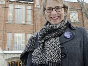 Christine Sypnowich, a member of the Save Kingston City Schools Coalition, stands in front of Kingston Collegiate earlier this year.