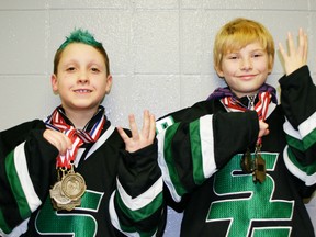 Jacob Nardelli (left) and Coleton Welch signal ‘4’ for the number of consecutive gold medals they’ve won with Spruce Grove teams in two different divisions during play in the huge Edmonton Minor Hockey Week tournament. - Gord Mongtomery, Reporter/Examiner