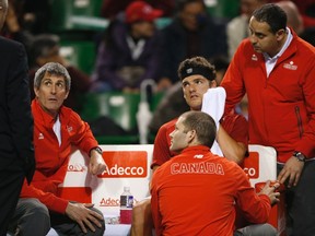 Canada's Frank Dancevic (centre) reacts with his team's coach Martin Laurendeau (second left) and team members as he retires from their Davis Cup first round match against Japan's Kei Nishikori in Tokyo on Sunday, Feb. 2, 2014. (Toru Hanai/Reuters)