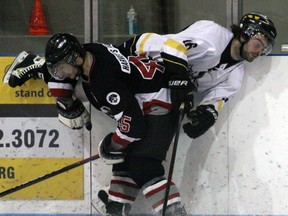 Tillsonburg Thunder forward Cody Chute is pinned to the boards by Goderich Pirate Steve Kewley Saturday evening at the Kinsmen/Memorial Arena. Chute had a goal and an assist through a 10-1 WOAA playoff victory.