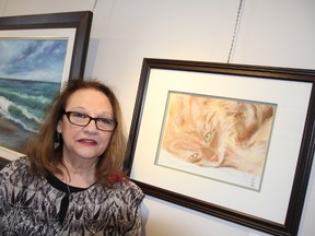 Kathy King shows off "Day Dreamer," a pastel portrait of her late cat, at Gallery in the Grove Sunday. The member of the 6 +1 Art Group actually started trying her hand at pastel thanks to the encouragement of another member. The group is currently the focus of the Winter Interlude show and sale this month. BARBARA SIMPSON/THE OBSERVER/QMI AGENCY