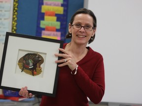Barbara Reid holds up a framed version of one of her plasticine illustrations.