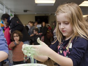 Joslin Howes, 5, learns about solid matter with the slimy material that only stays solid when you keep it moving, during Science Discovery Day held at Queen's University on Saturday. JULIA MCKAY/The Whig-Standard