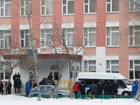 Interior Ministry members in uniform and other authorities gather outside a high school, where a student shot a teacher and a police officer dead and held more than 20 other students hostage, on the outskirts of Moscow, February 3, 2014.  (REUTERS/Maxim Shemetov)