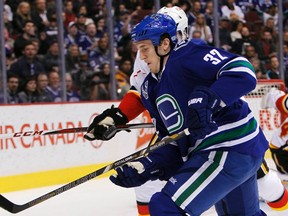 Vancouver Canucks forward Dale Weise (32) fights for the puck with Brett Carson of the Calgary Flames during NHL action in Vancouver April 6, 2013. (REUTERS/Ben Nelms)