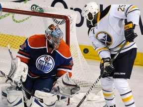 Buffalo Sabres' Mike Grier (R) and Edmonton Oilers' goalie Nikolai Khabibulin watch a loose puck during the first period of their NHL hockey game in Edmonton December 28, 2010. REUTERS file photo