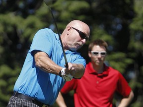 Victor Schnare tees off as his son Kristopher watches during play in the Ottawa SUN Scramble City Championship last year. Golfers who made the cut at last year's tournament are invited to pre-register for this year's event. (Errol McGihon/Ottawa Sun/QMI Agency)
