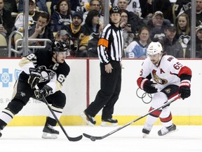 Sidney Crosby battles with Erik Karlsson during first-period action in Pittsburgh Monday night. USA TODAY