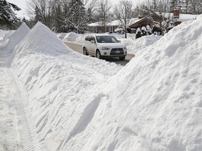 A giant snowbank frames a passing motorist. (Postmedia)
